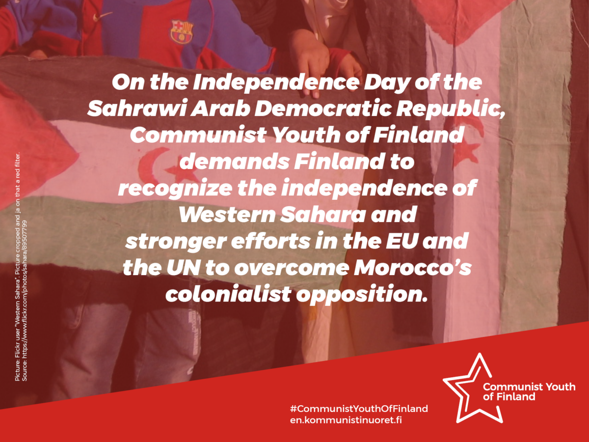 In the background photo, the flags of Western Sahara are held in the hands, a reddish filter over the image and a white text over it "On the Independence Day of the Sahrawi Arab Democratic Republic, Communist Youth of Finland demands Finland to recognize the independence of Western Sahara and stronger efforts in the EU and the UN to overcome Morocco’s colonialist opposition." and below, the Communist Youth logo, hashtag and website address.